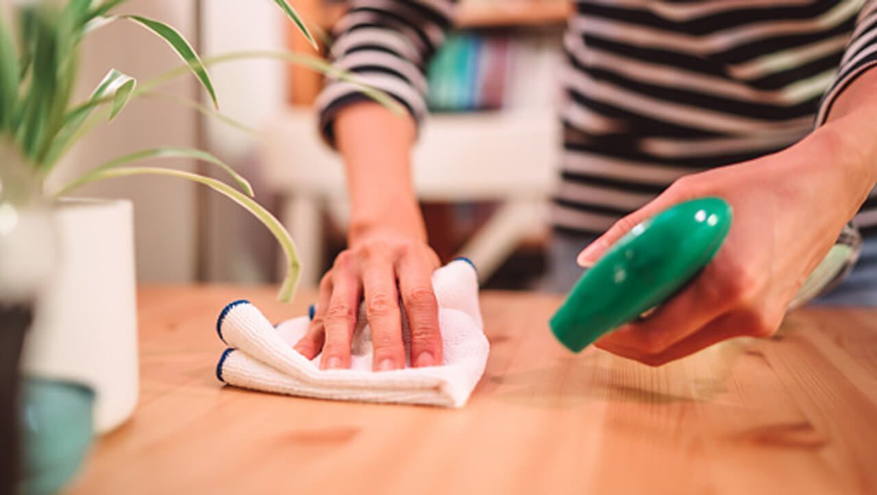 Σκούπισμα τραπεζιού ενώ κρατάει σπρέι